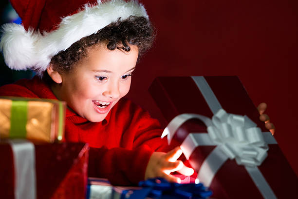 istock Excited child opening a gift under the Christmas tree 187709432