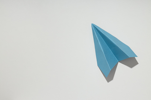 Business, startup and sponsorship concept with paper plane on white background