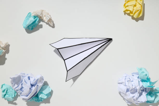 istock Paper plane and paper balls on white background 1877110012