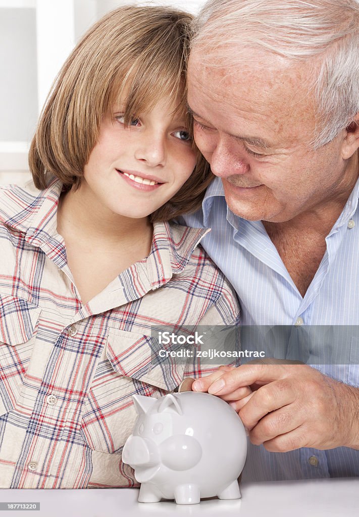 Abuelo enseñanza nieto a ahorrar dinero en una alcancía - Foto de stock de 4-5 años libre de derechos