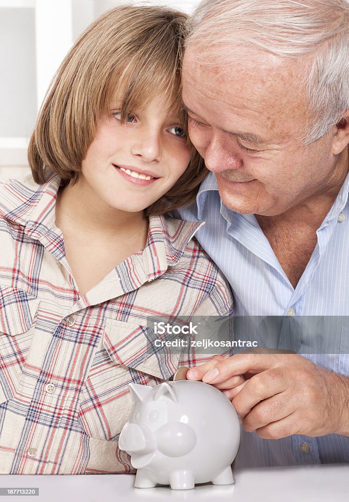 Avós e Avôs ensino neto para economizar dinheiro em um piggy bank - Foto de stock de 4-5 Anos royalty-free