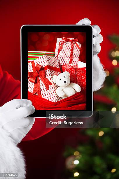 Foto de Papai Noel Segurando Um Tablet Com Foto De Natal Apresenta e mais fotos de stock de Adulto