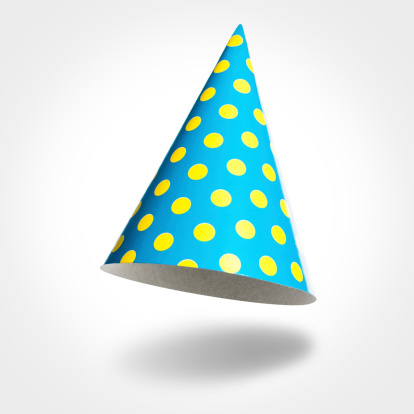 Blue party hat in the air with yellow spots isolated on white background, vignetting, shadow. Studio shot.