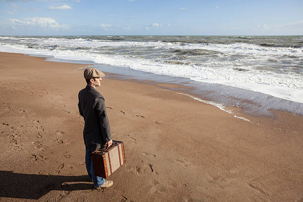 istock Walking man holding suitcase in the beach 187714521