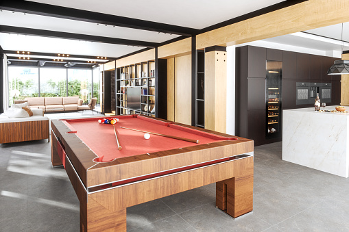 A billiard table in the living room of a luxurious house.