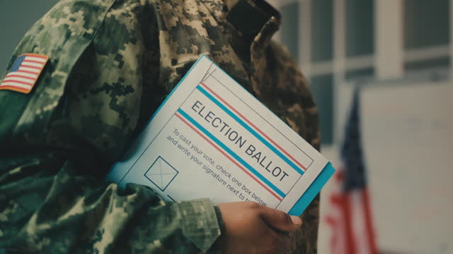 American military officer holding election ballot, voting day at polling station