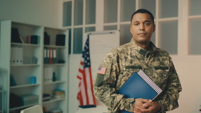 Portrait of African American military man holding books, education in the army