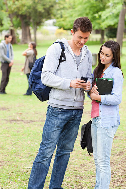 istock Student showing something on his smartphone to a friend 187717811