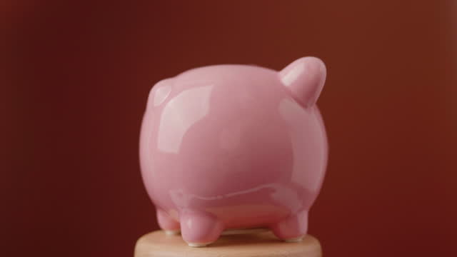 Saving coins in a piggy bank Create a habit of saving money, coin banks, savings and financial investment ideas.