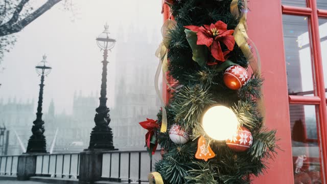 A red telephone booth in England decorated with a Christmas tree