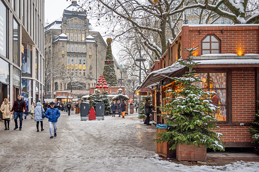 Mönckebergstrasse, Hamburg, Germany - December 6th 2023:  Entrance to a small Christmas market with Christmas trees and snow