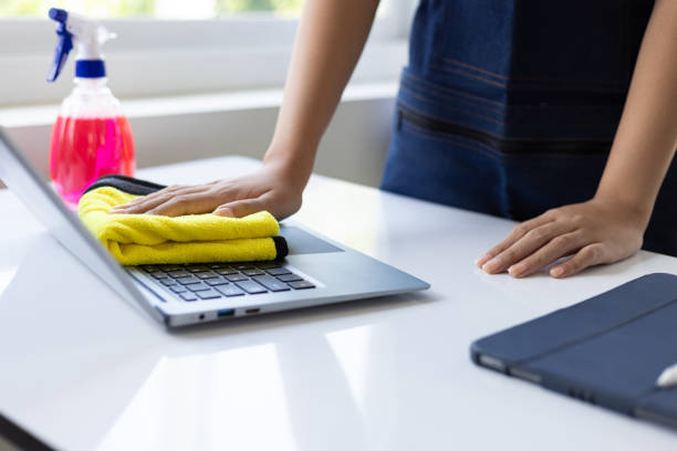 istock Young Asian cleaning woman uses a towel to clean a computer using cleaning solution in her home office. 1877219450