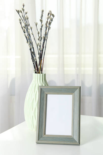istock A photo frame with a vase on the table, near the window 1877242938
