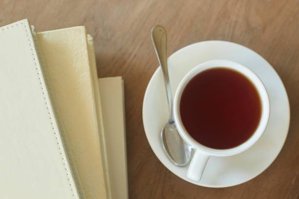 istock A cup of tea on the table and leather-bound books. 1877253501