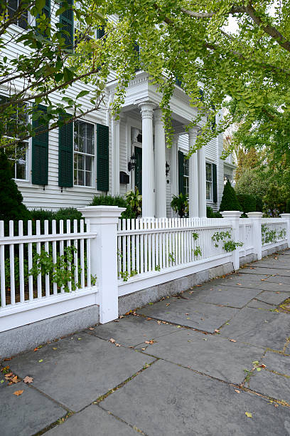 istock white picket fence by a typical federal style house 187729779