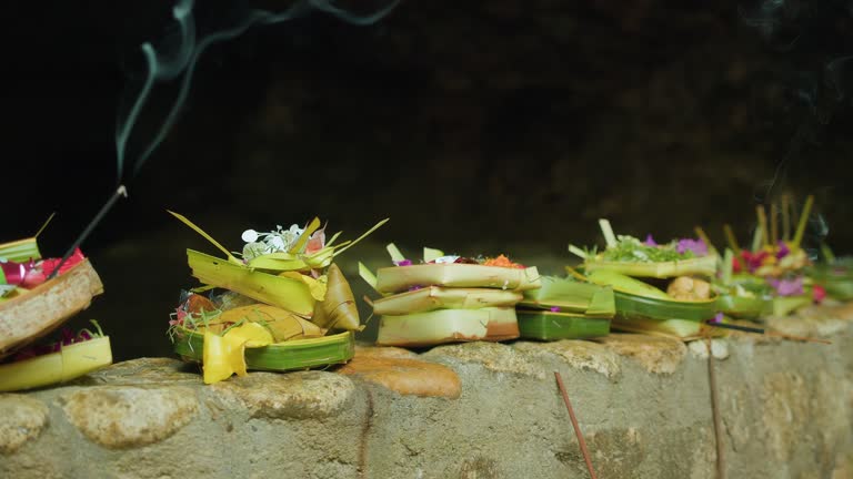 Canang Sari daily offerings made by Balinese Hindus to thank God Deva in praise and prayer. Baskets of flowers and burning incense sticks.