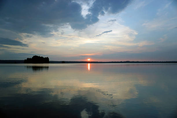 istock Summer. Forest lake Bright sky at sunset and bright clouds. Reflection in water. 1877312181