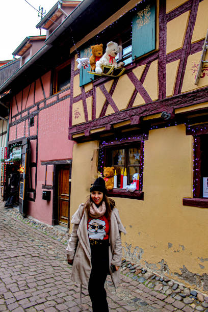 Image of a woman in the streets of the village of Eguisheim, in Alsace. The image was taken in December 2022