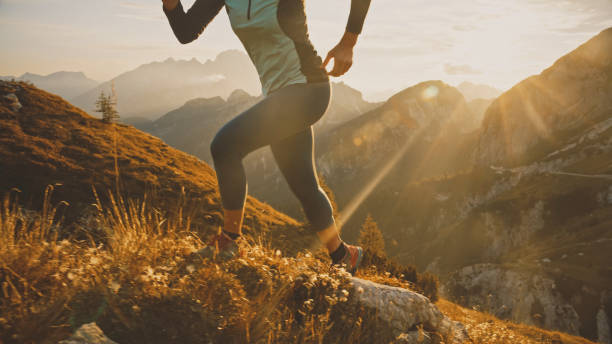 istock Low Section of Determined Female Sprinter Running on Rocky Mountain During Bright Sunny Day 1877338371