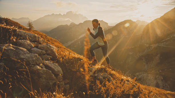 istock Determined Female Sprinter Running on Rocky Mountain During Bright Sunny Day 1877338381