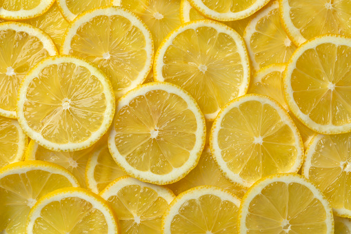 Fresh raw juicy lemon slices full frame close up as background
