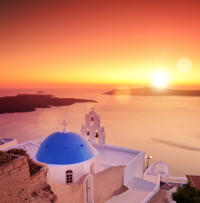 View of a blue dome of the church St. Spirou in Firostefani on the island of Santorini Greece, at sunset