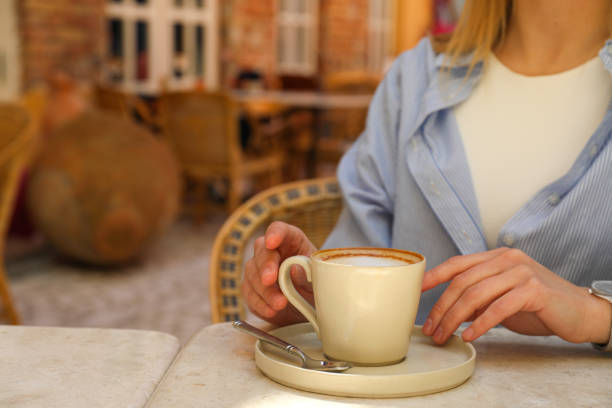 istock Cup of coffee on table and female hands, space for text 1877366321