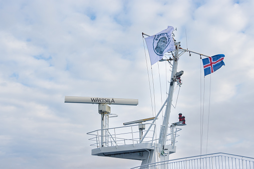 Hirtshals, Denmark : August 10, 2022 : Sailors and Workers on a Boat switch flags between Sweden, Denmark and Iceland depending upon the country's port they dock at.