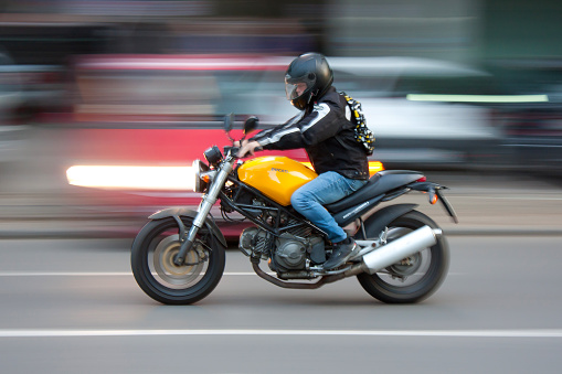 Woman drives on a motorcycle on a country road