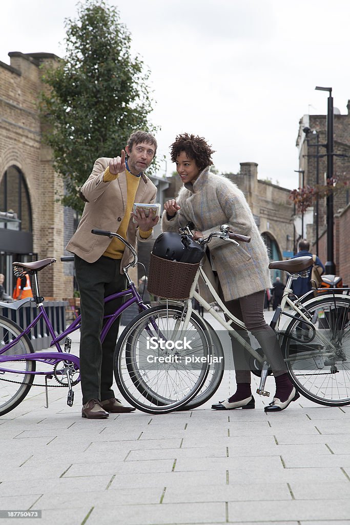 Which way? a couple resting on bicycles looking at the map Adult Stock Photo