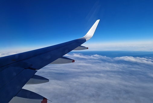 Plane wing, blue sky and white clouds