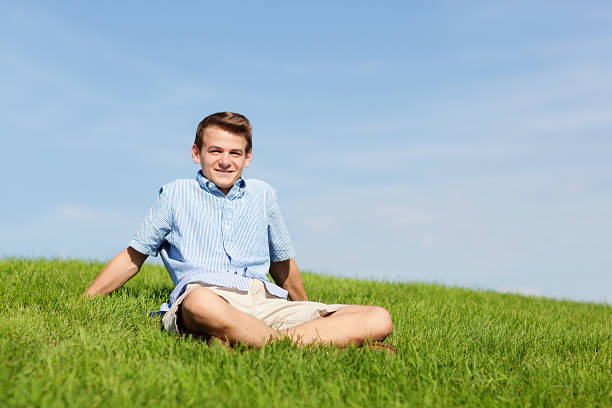 istock Young Man Siiting Outdoor on Meadow 187751673