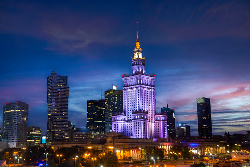 Palace of Science and Culture and skyscrapers illuminated in evening, Warsaw