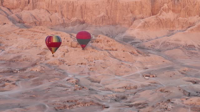 Hot air balloon flying over Hatshepsut Temple at sunrise