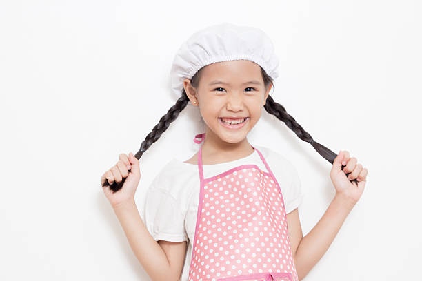 istock Little Asian cute chef wearing pink apron 187755327