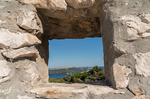 High angle view through stone wondow on Telascica, national park in Dugi otok island, Kornati islands in background. Croatia