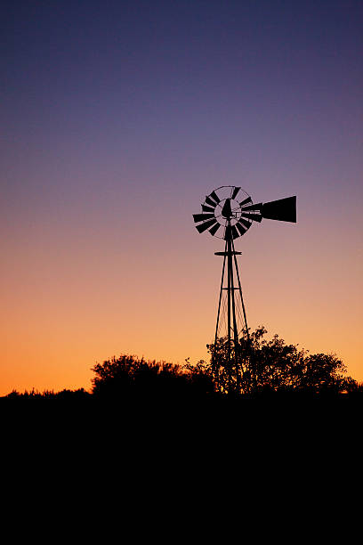 istock Silhouette of an old farm windmill at dusk 187756088