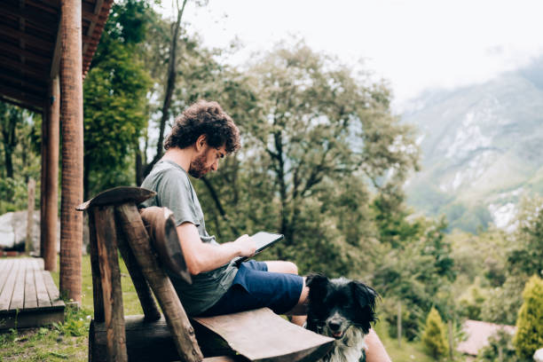 istock Man using digital tablet at country house 1877580318