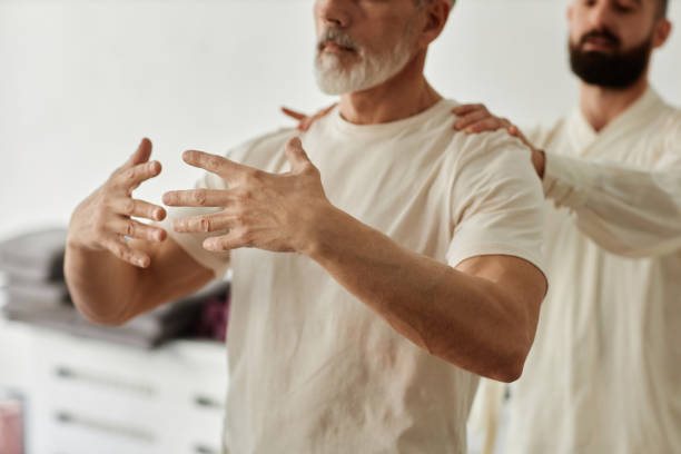 istock Instructor Adjusting Position of Senior Qigong Student 1877662500