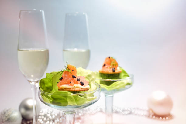 за�куска из копченого лосося с икрой и листьями салата в бокалах, два бокала для шампанского и праздничное оформление, праздничная закуска, � - canape buffet cocktail food стоковые фото и изображения