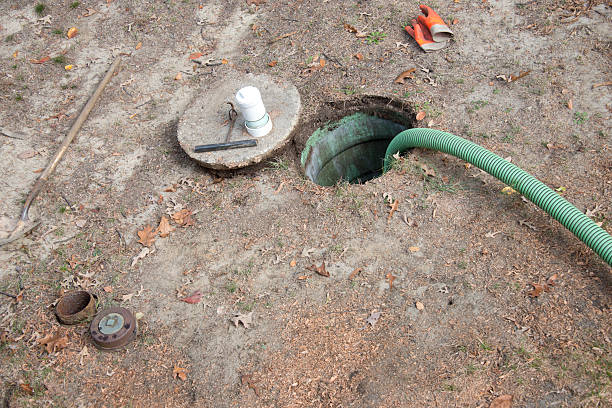 Pumping a Home Septic Tank Hose pumping out  home septic tank. flushing water stock pictures, royalty-free photos & images