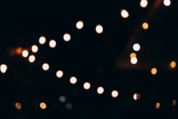 istock Golden bokeh, raining light, blurry lights, blurry background, gold confettis on a black background, yellow and orange, night lights, city lights, haze, depth of field, round bokeh, circle bokeh 1877747917