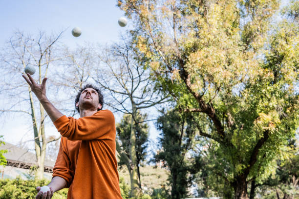 Mid adult man practicing juggling at the public park