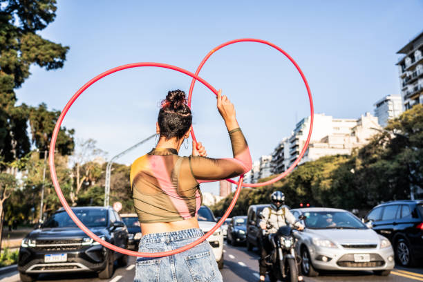 istock Juggler performing with hula hoops in city traffic 1877780961