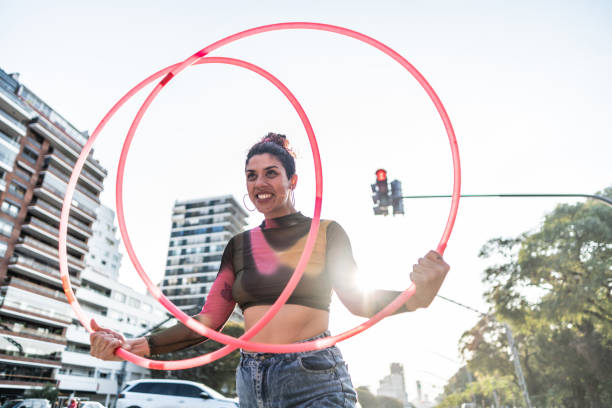 istock Juggler performing with hula hoops in city traffic 1877782006