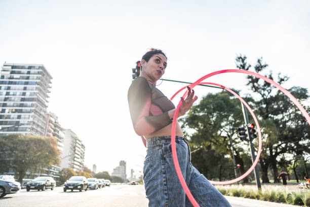 istock Juggler performing with hula hoops in city traffic 1877782012