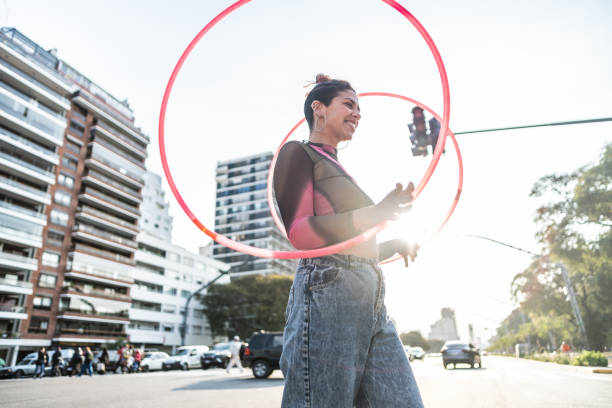istock Juggler performing with hula hoops in city traffic 1877782015