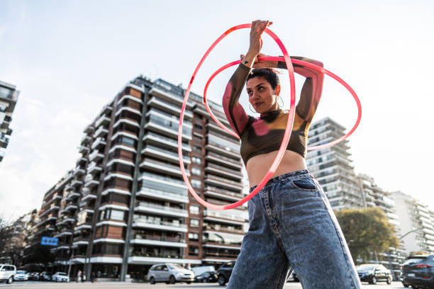 istock Juggler performing with hula hoops in city traffic 1877782018