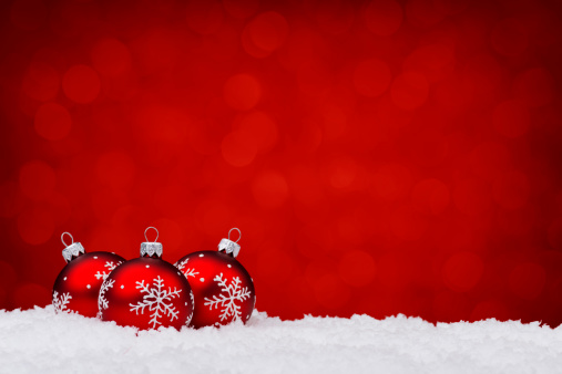 Red decorated with snowflake baubles lying on Snow, nice christmas red lights background