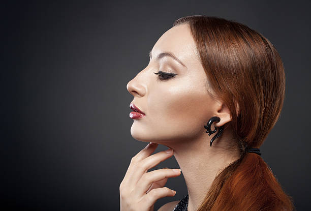 istock beautiful young redhead woman isolated on dark background with copyspace 187782207